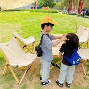 Outdoor close-up of durable nylon kids' chest bags in black and blue with SUP letters