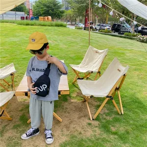 Outdoor view of child wearing black crossbody chest bag with SUP letters and yellow cap