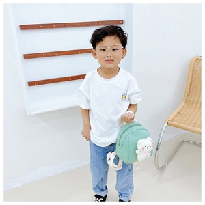 Detail of mint green toddler backpack with white plush bear charm and fabric straps