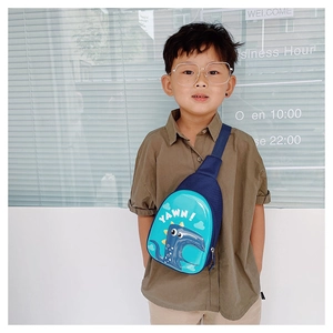 Detail of dark blue dinosaur crossbody bag with adjustable strap worn by a child
