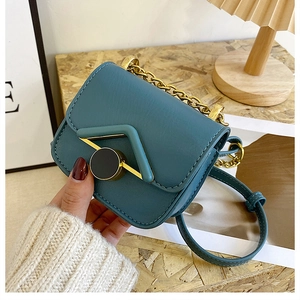 Dettaglio della mini borsa a tracolla color teal con trama in pelle e catena