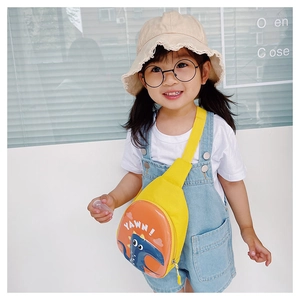 Cute yellow dinosaur egg crossbody bag shown on a young girl in a bright setting