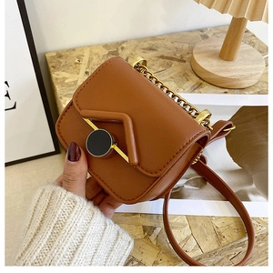 Dettaglio della mini borsa a tracolla marrone vintage con catena dorata e patta magnetica