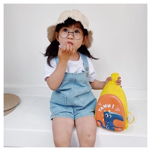 Detailed view of yellow dinosaur eggshell crossbody bag featuring YAWN text and orange shell
