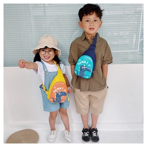 Kids wearing dinosaur egg cross-body bags with adjustable straps in blue and yellow