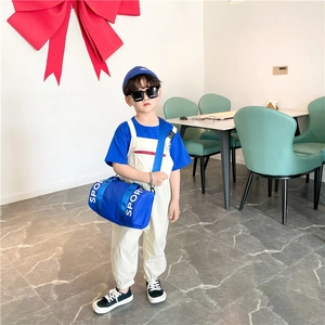 Detail view of the durable royal blue nylon cylinder crossbody bag for kids' sports