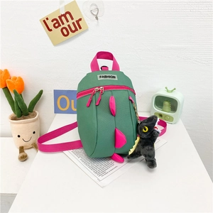 Détail du sac à dos dinosaure enfant avec fermetures roses et porte-clés dinosaure en peluche