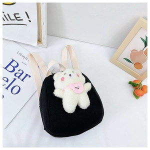 Detail of cute black canvas backpack with 3D white plush bear and pink scarf detail
