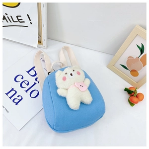 Detail view of mini blue canvas kids backpack with a cute white plush bear attached