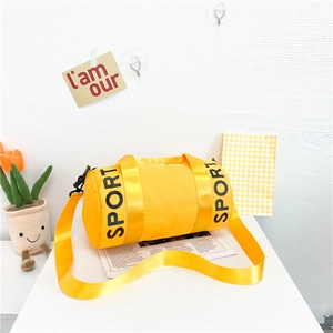 Detail view of bright yellow cylinder sports bag with adjustable strap and handles
