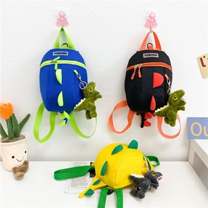 Détail de sacs à dos dinosaures colorés avec ailerons 3D et porte-clés en peluche assortis