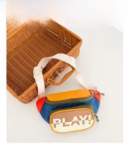 Detail of multi-color block kids belt bag featuring PLAY text and adjustable strap