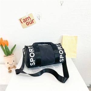 Detail of black nylon sport duffel bag with white lettering on a bright lifestyle setting
