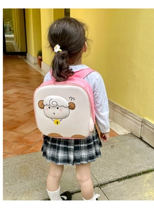 Detail of pink and white egg-shaped kids backpack with 3D lamb and yellow bell