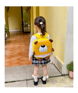 Detailed back view of toddler wearing a yellow cartoon bear hardshell backpack with wide straps