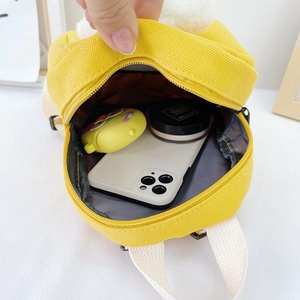 Yellow canvas kids backpack showing interior capacity with phone and accessories