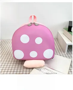 Detail of pink mushroom backpack with white polka dots on a checkered tablecloth