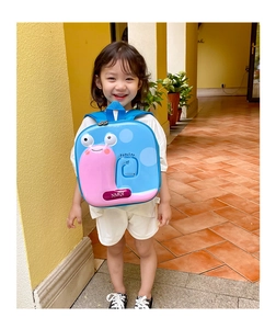 Detail of blue eggshell toddler backpack with pink snail character and metal logo
