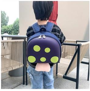 Detail of purple mushroom kids backpack featuring bright green polka dots and pink base