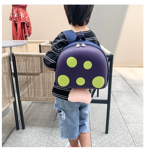 Detail of cute purple mushroom backpack with green dots and adjustable blue straps