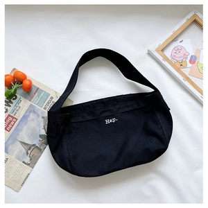 Detail of black canvas shoulder bag with minimalist Hey embroidery and wide strap design