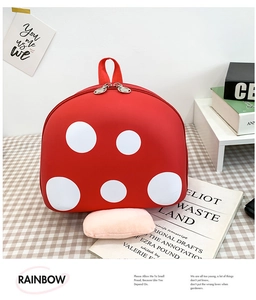 Detail of red mushroom backpack with white polka dots and dual metal zipper closure