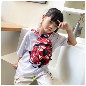 Close-up of red toddler backpack with dinosaur silhouette prints and 3D spinal scales