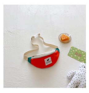 Détail du sac banane enfant bicolore rouge et vert avec sangle réglable et écusson