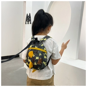 Macro view of dinosaur pattern toddler backpack with yellow fins and safety leash