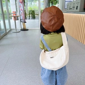 Kids white canvas crossbody bag with embroidery paired with a brown leather beret hat