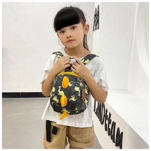 Close-up of a child wearing a dinosaur backpack with 3D yellow spikes and navy print