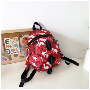 Detail of red toddler dinosaur backpack with 3D black spines and adjustable straps