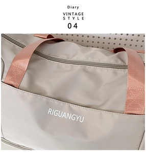 Close-up of beige travel bag featuring reinforced rose gold handles and vintage logo