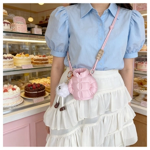 Pink quilted down-jacket style mini crossbody bag with a cute white plush doll charm