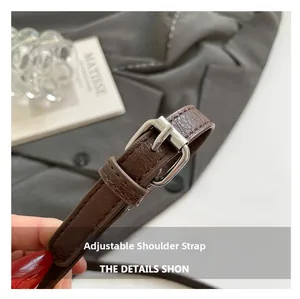 Close-up of brown litchi pattern leather strap with adjustable silver metal buckle