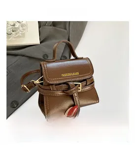 Close-up of brown faux leather mini bag with gold buckle and Fashion & Bags text