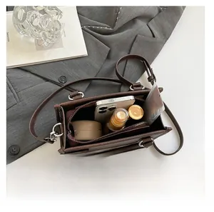 Internal view of brown leather handbag showing large capacity for phone and cosmetics