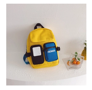 Detailed view of kids color-block canvas backpack with dual front pockets and text motifs