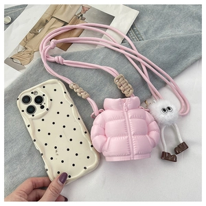 Pink mini puffer crossbody bag with fluffy charm and polka dot case on denim base