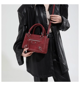Fashionable dark red motorcycle bag featuring metallic rivets and buckled leather straps