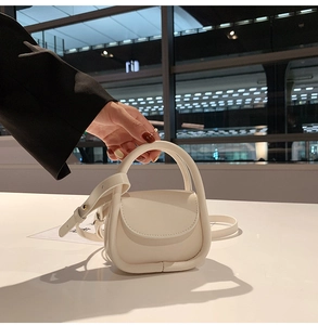 Close-up of white PU leather mini square handbag with round top handle and shoulder strap