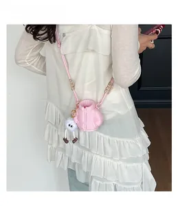 Close-up of pink puffer jacket shaped mini bag with cute monster plush and wooden beads