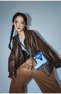 Detail view of cartoon rain boot shaped crossbody bag in blue with metal buckle closure