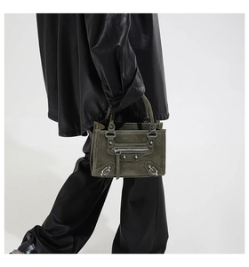 Close-up of olive green motorcycle bag featuring vintage rivets and long tassel details