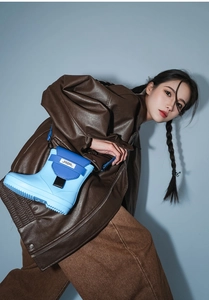 Close-up of a creative rain boot shaped shoulder bag in blue with adjustable nylon strap