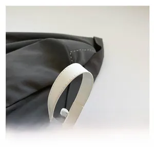 Detailed close-up of the white bucket bag handle featuring refined stitching and premium PU texture