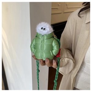 Detailed view of mini green puffer jacket bag with plush monster head and woven strap