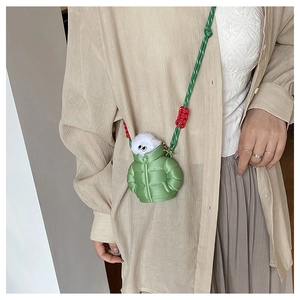 Mini green puffer jacket bag with cute plush doll and colorful woven strap