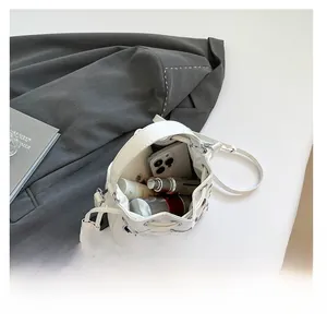 Top view of white bucket bag showing inner space with phone and cosmetics