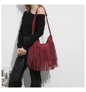 Detail view of burgundy fringe tote bag with soft suede texture and long tassels